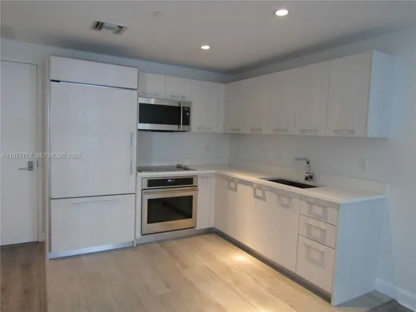 a kitchen with a sink cabinets and stainless steel appliances