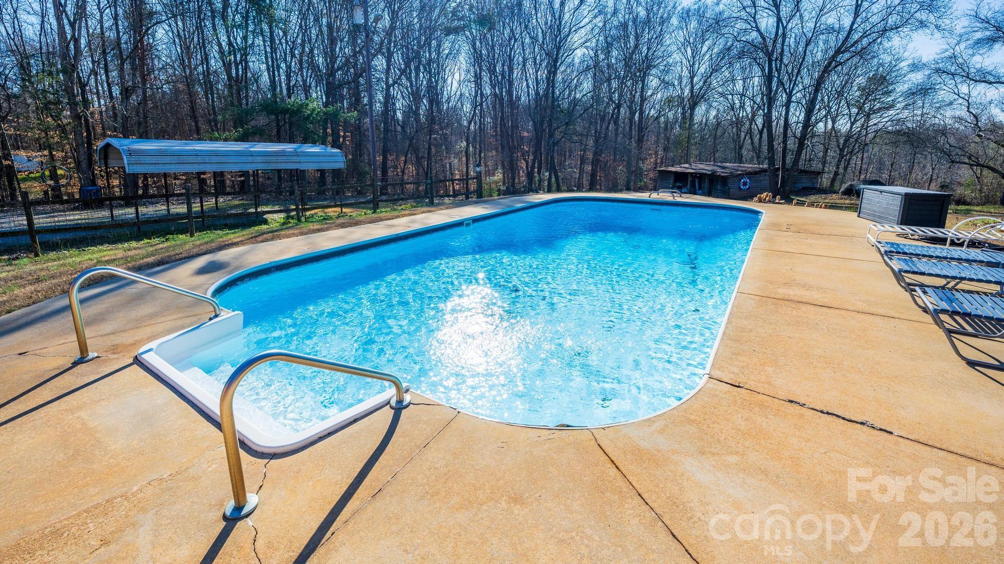 11443 Mooresville Road Davidson, NC 28036 - Photo 27 of 47 a view of swimming pool with seating area and trees in the background