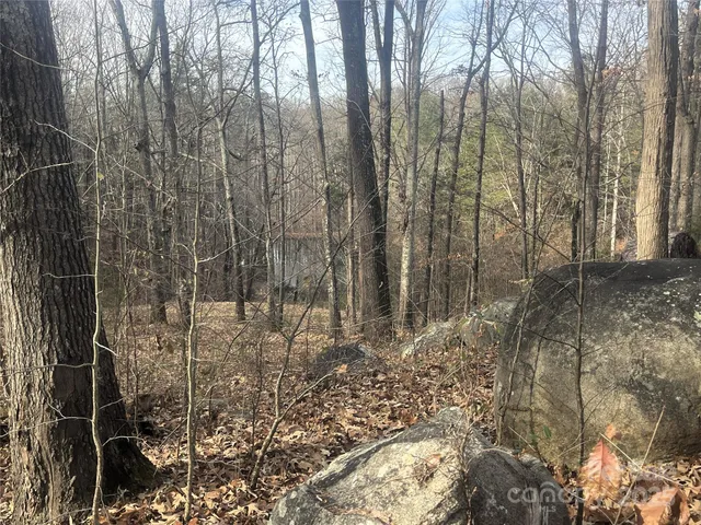 a view of a patio with table and chairs under an umbrella with a small yard