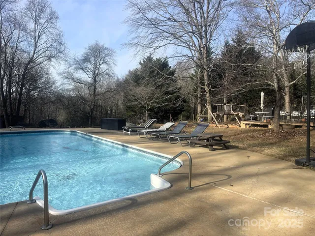 a view of yard with swimming pool and seating space