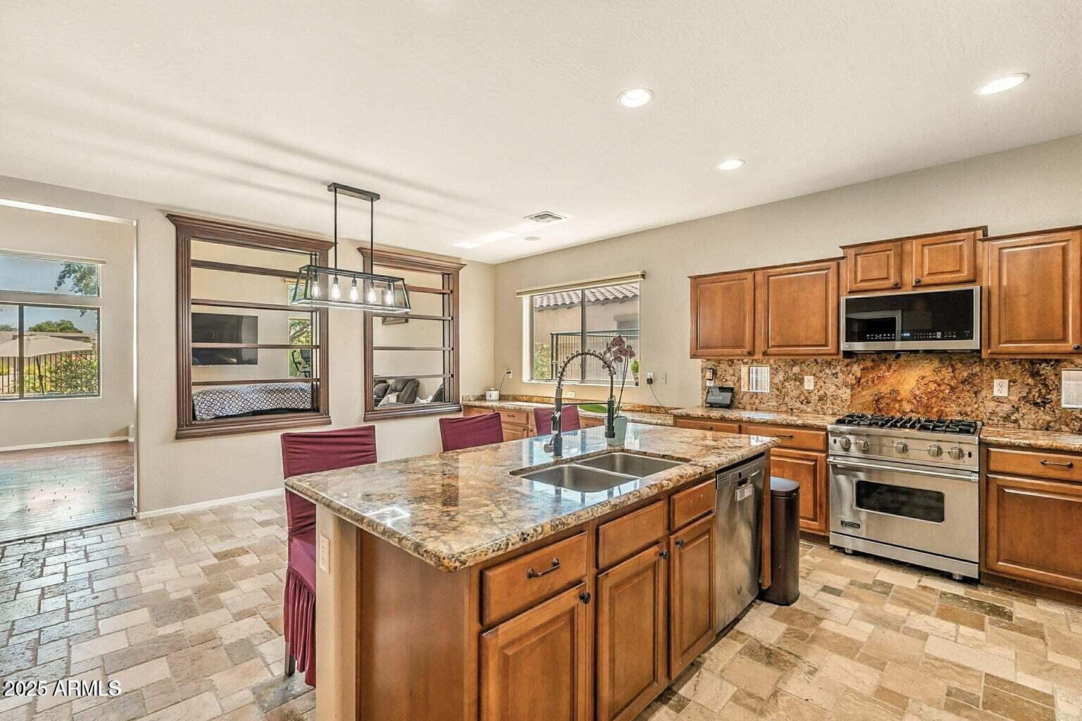 7169 South Dodane Court Gilbert, AZ 85298 - Photo 5 of 23 a kitchen with stainless steel appliances granite countertop a sink stove and refrigerator