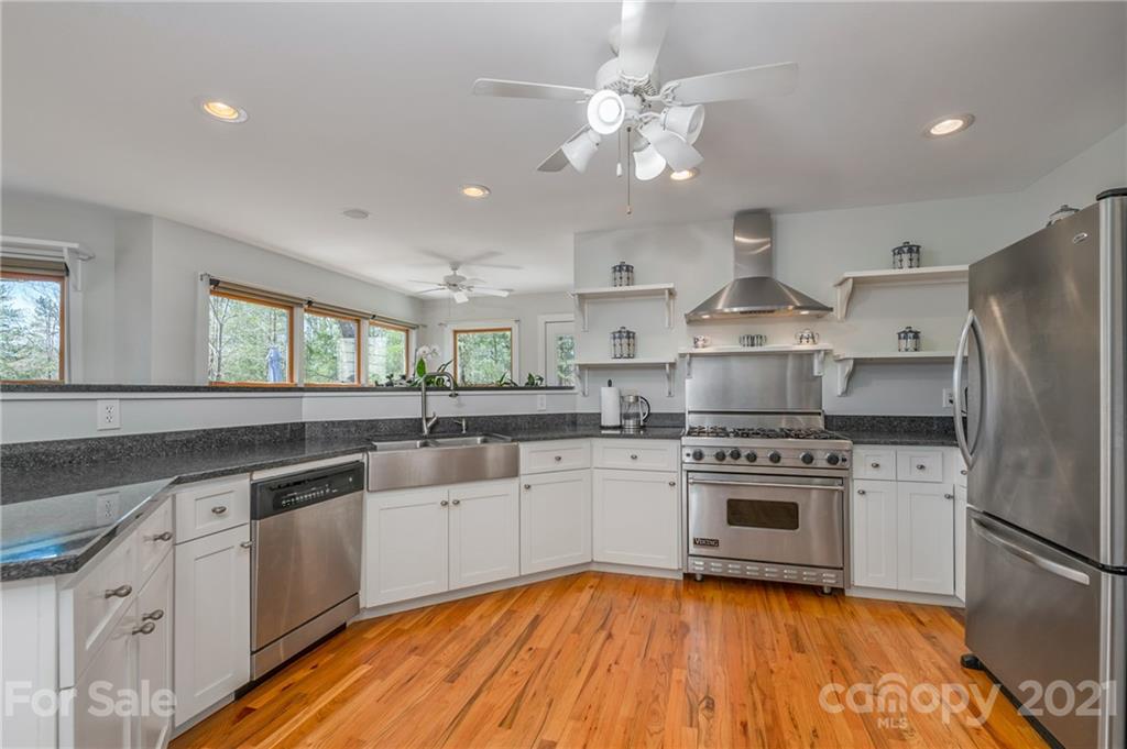 658 South Cove Road Mill Spring, NC 28756 - Photo 16 of 46 a kitchen with stainless steel appliances a sink cabinets and wooden floor