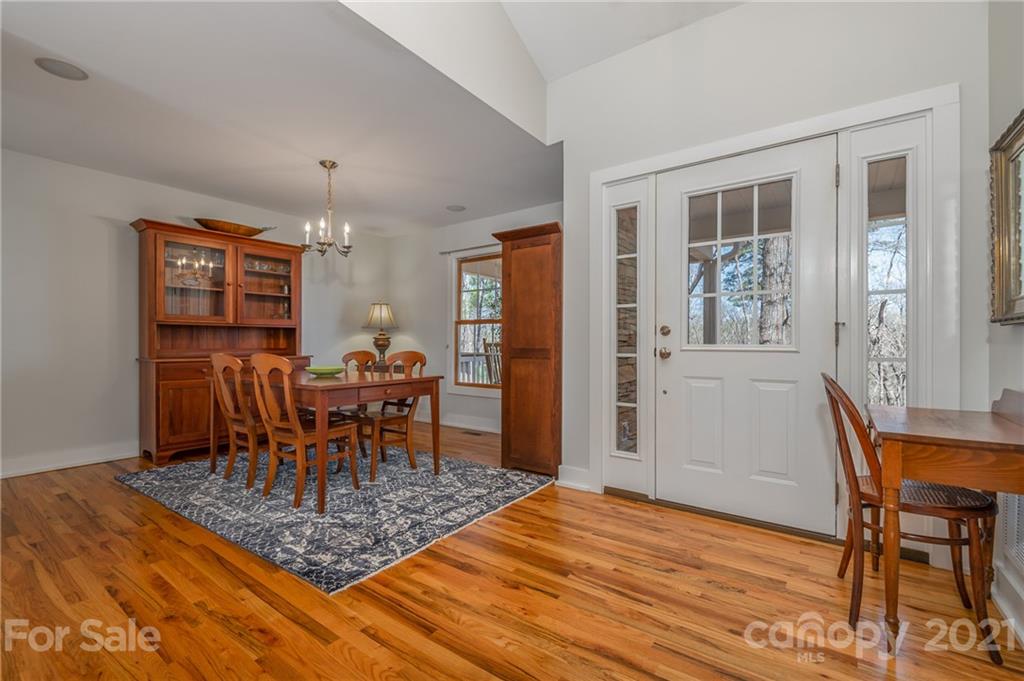 658 South Cove Road Mill Spring, NC 28756 - Photo 19 of 46 a dining room with furniture a chandelier and wooden floor