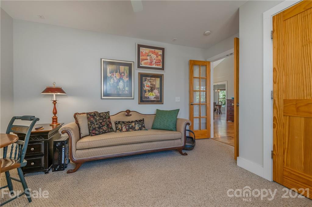 658 South Cove Road Mill Spring, NC 28756 - Photo 22 of 46 a living room with furniture and a baby crib with a book shelf