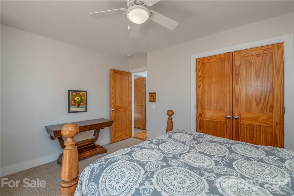 658 South Cove Road Mill Spring, NC 28756 - Photo 25 of 46 a bedroom with a bed and a chandelier