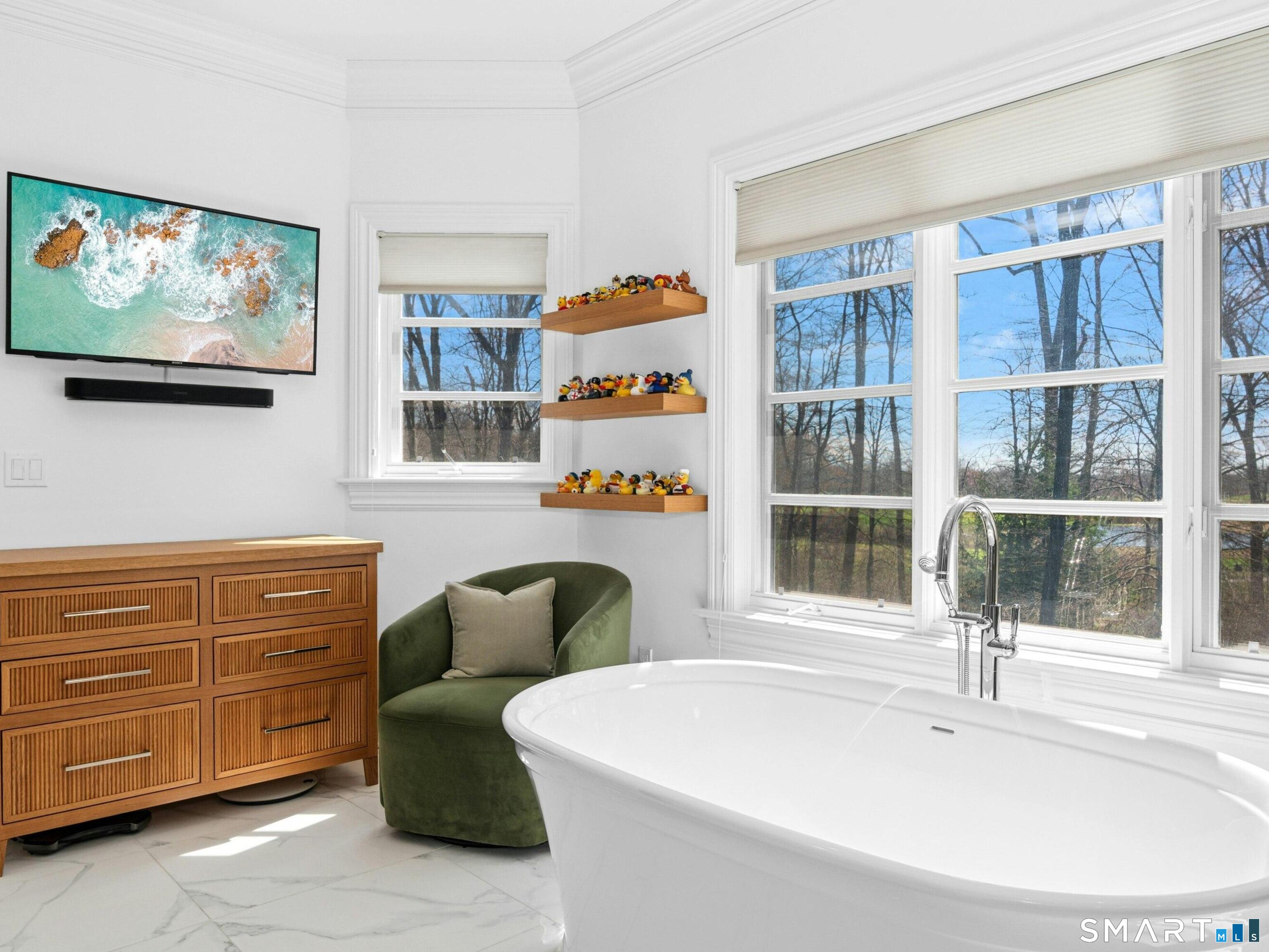 760 Smith Ridge Road New Canaan, CT 06840 - Photo 25 of 38 a living room with furniture a flat screen tv and a window