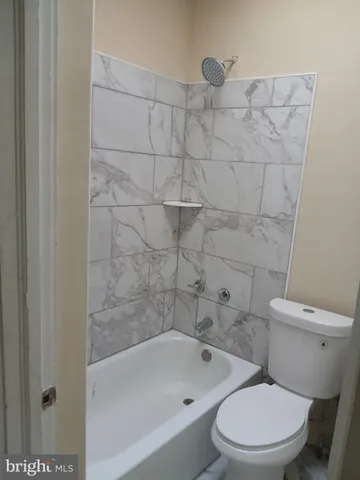 a white toilet and tub sitting next to a bathroom sink