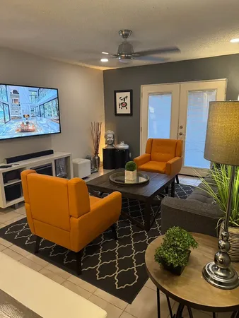 a living room with furniture a rug and a lamp