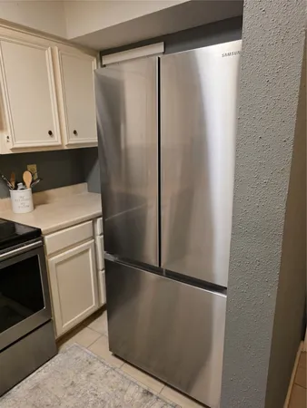a white refrigerator freezer and a stove sitting inside of a kitchen