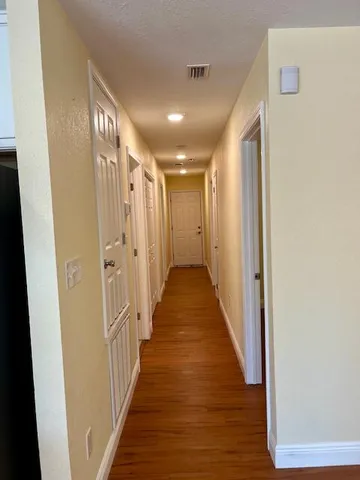 a view of a hallway with wooden floor
