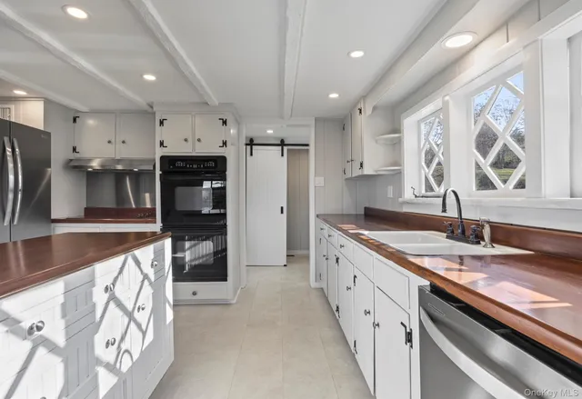 a large kitchen with stainless steel appliances granite countertop a lot of counter space and a sink