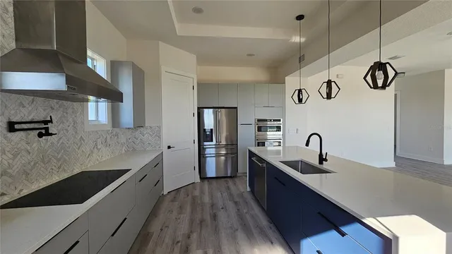 a kitchen with stainless steel appliances granite countertop a sink a stove and refrigerator