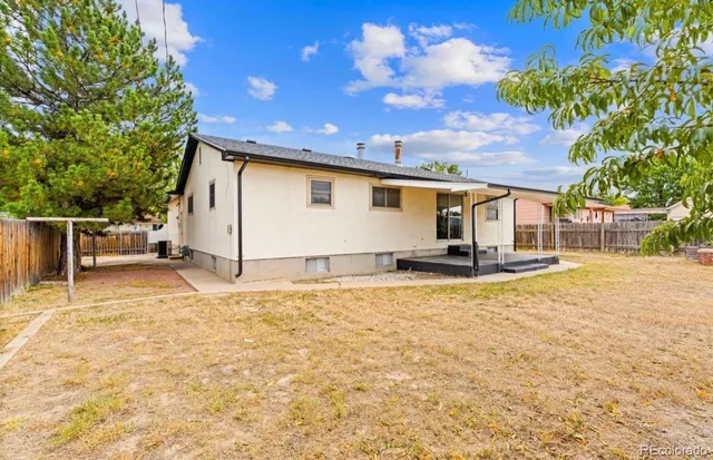 a backyard of a house with table and chairs