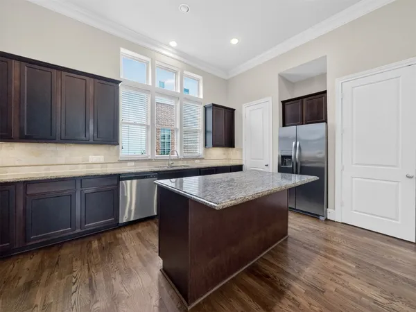 a kitchen with kitchen island granite countertop wooden cabinets and a counter top space