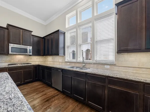 a kitchen with granite countertop wooden cabinets a stove top oven and granite counter tops