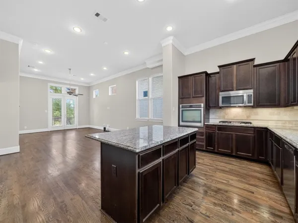 a kitchen with stainless steel appliances granite countertop a stove a sink and a refrigerator