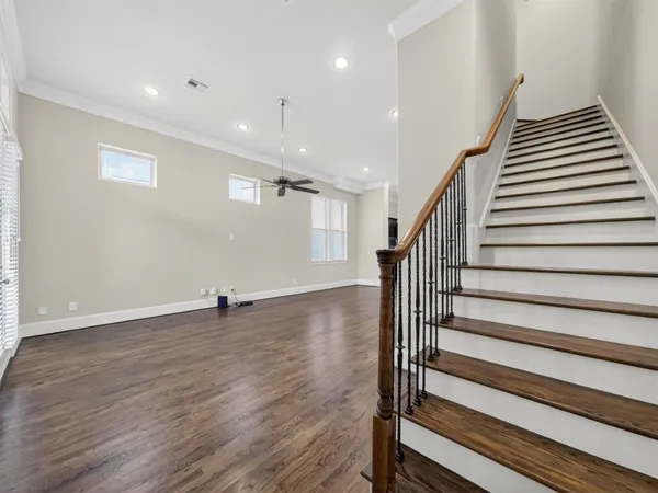 a view of a livingroom with wooden floor and stairs