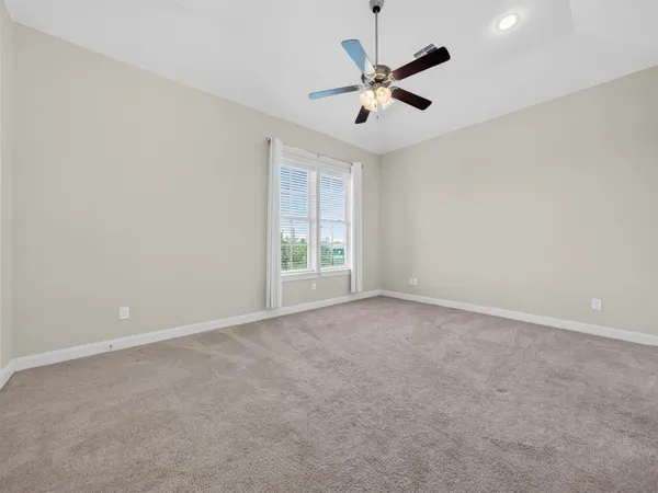 an empty room with a window and a fan