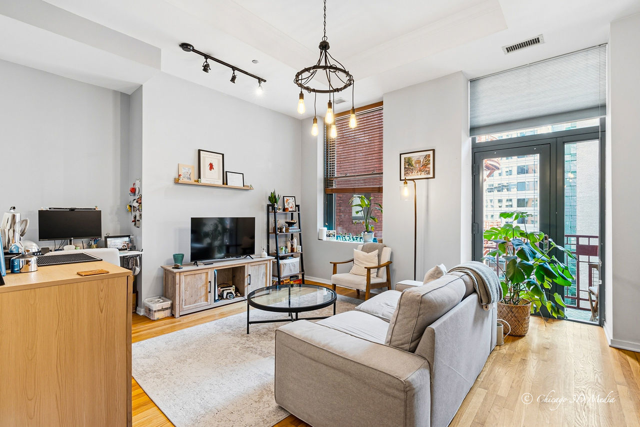 208 West Washington Street, Unit 1007 Chicago, IL 60606 - Photo 7 of 18 a living room with furniture a potted plant and a flat screen tv
