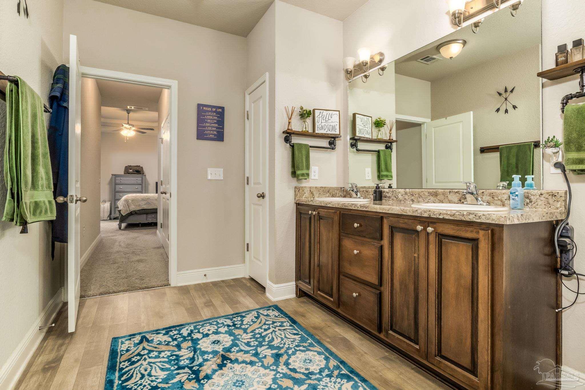 5185 Parkside Drive Pace, FL 32571 - Photo 14 of 43 a bathroom with a sink a mirror and a shower