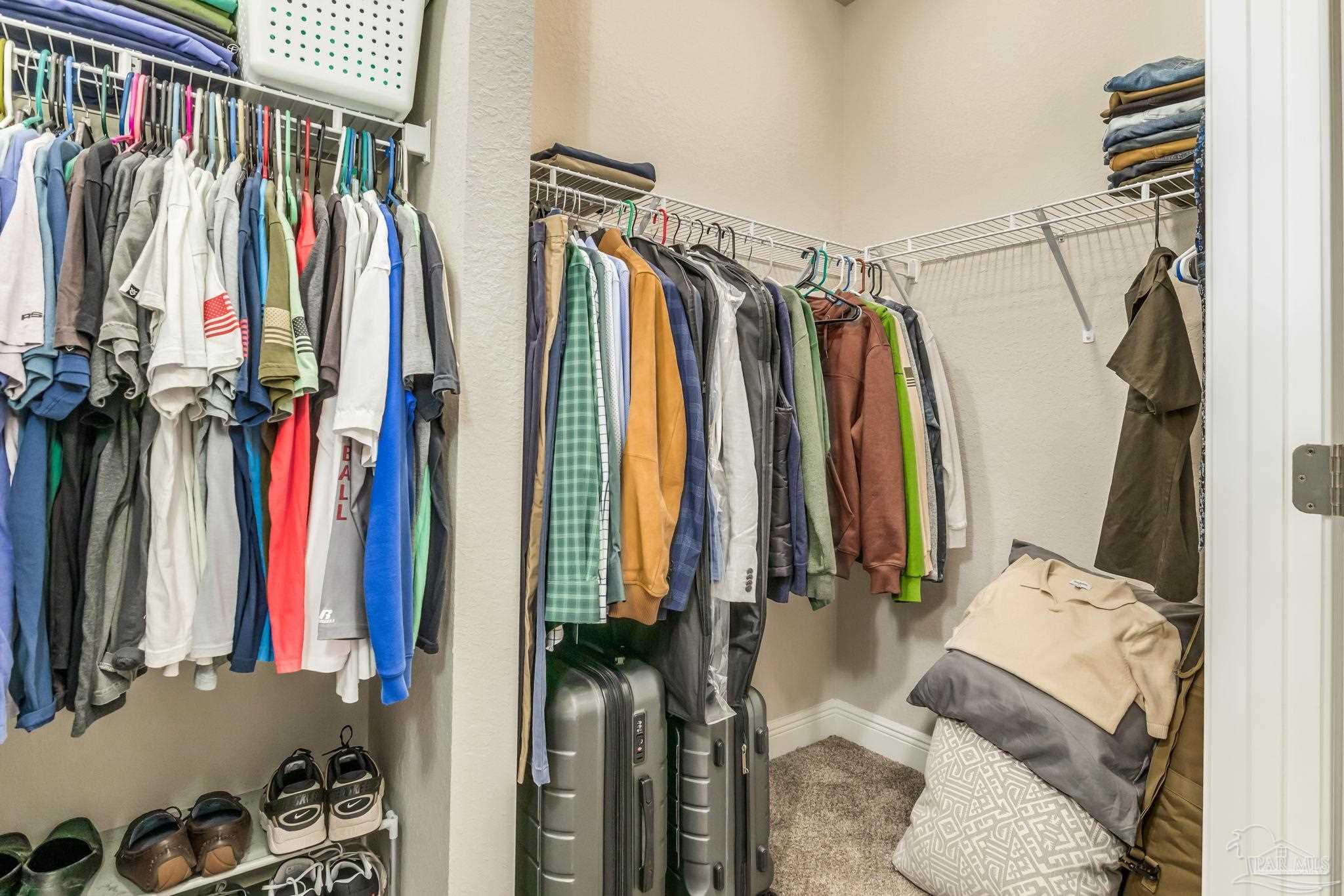 5185 Parkside Drive Pace, FL 32571 - Photo 16 of 43 a view of walk in closet with clothes and shoes