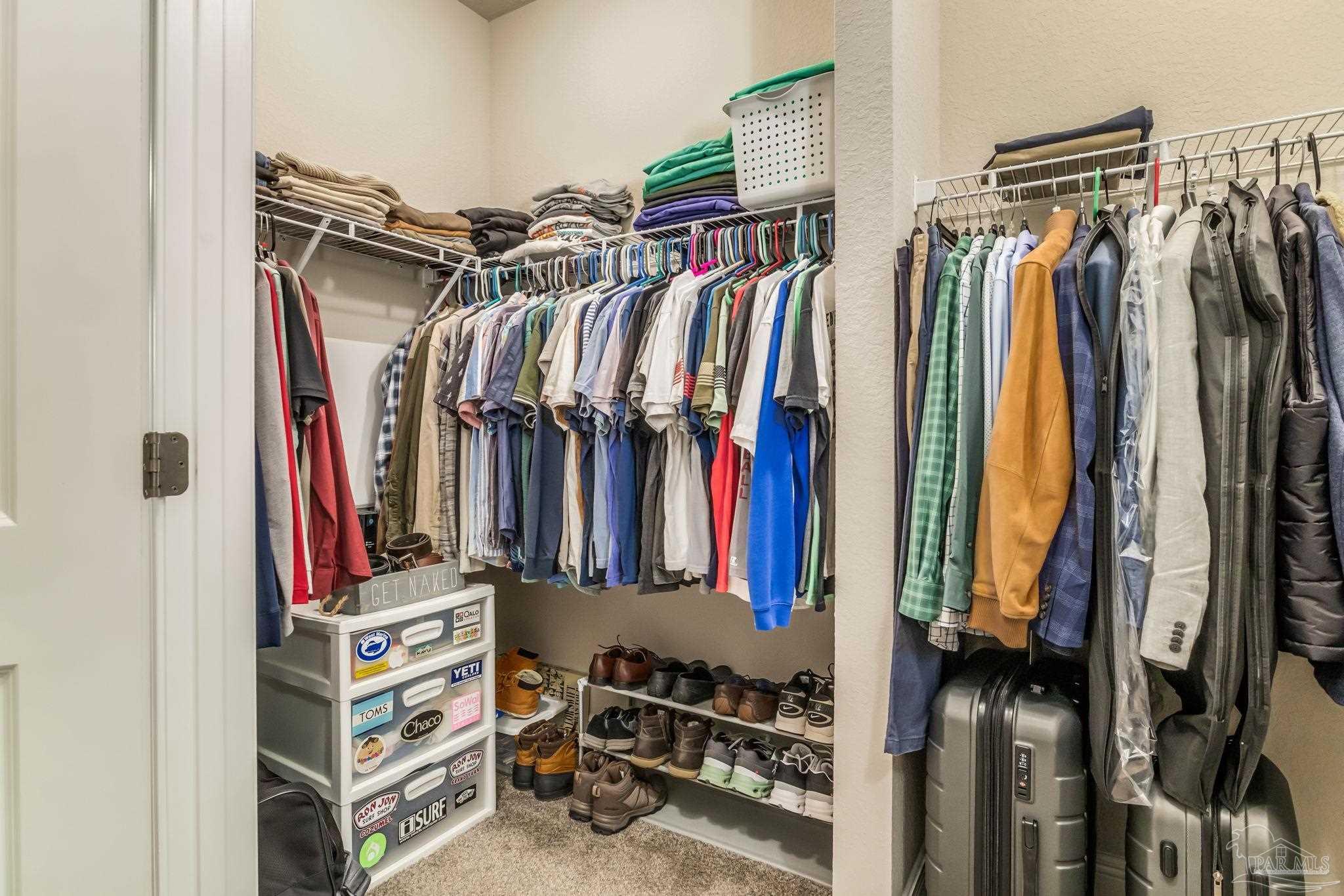 5185 Parkside Drive Pace, FL 32571 - Photo 18 of 43 a view of walk in closet with clothes and shoes