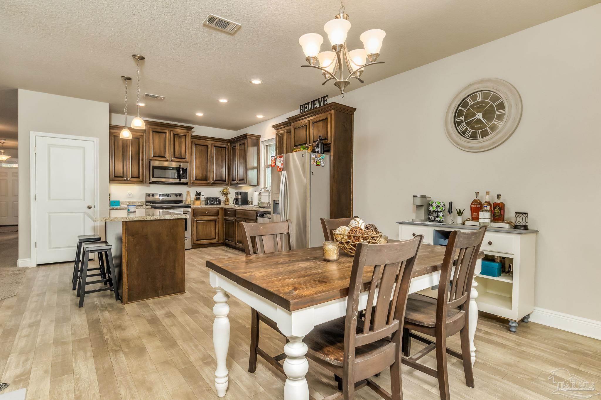 5185 Parkside Drive Pace, FL 32571 - Photo 22 of 43 a view of a dining room and livingroom with furniture wooden floor a kitchen view and chandelier