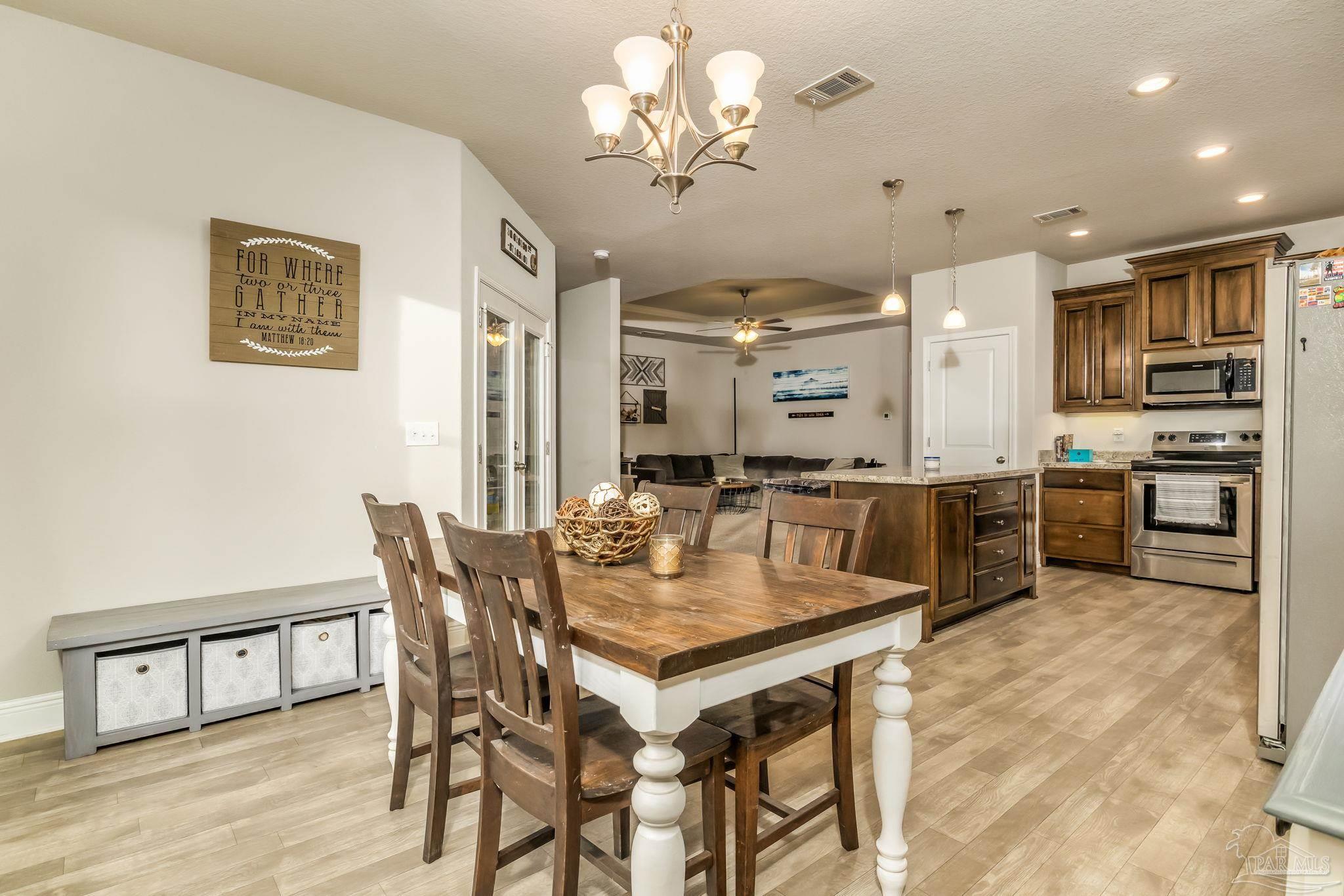 5185 Parkside Drive Pace, FL 32571 - Photo 23 of 43 a dining room with stainless steel appliances kitchen island granite countertop a dining table chairs and oven
