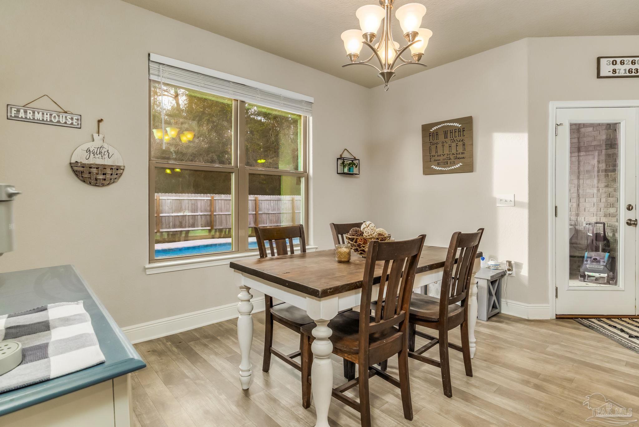 5185 Parkside Drive Pace, FL 32571 - Photo 25 of 43 a view of a dining room with furniture and wooden floor