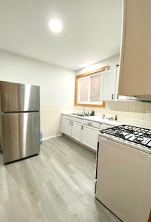 5225 West Deming Place, Unit 2 Chicago, IL 60639 - Photo 11 of 29 a kitchen with stainless steel appliances granite countertop a refrigerator a stove a sink and a microwave