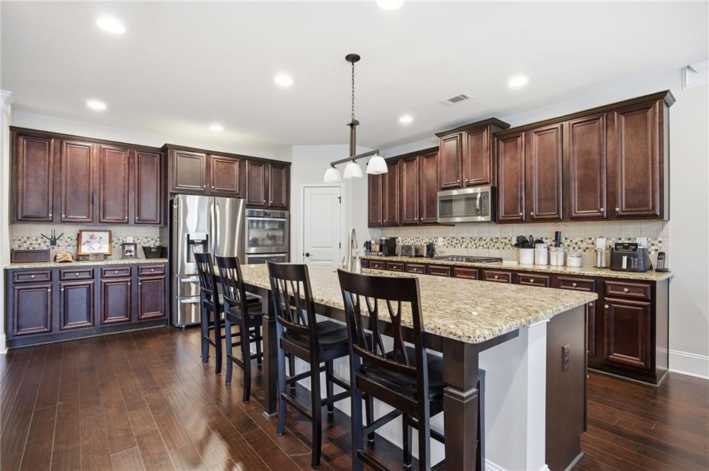 79 Gray Trail Acworth, GA 30101 - Photo 11 of 40 a kitchen with stainless steel appliances granite countertop a stove a sink a microwave a center island and chairs