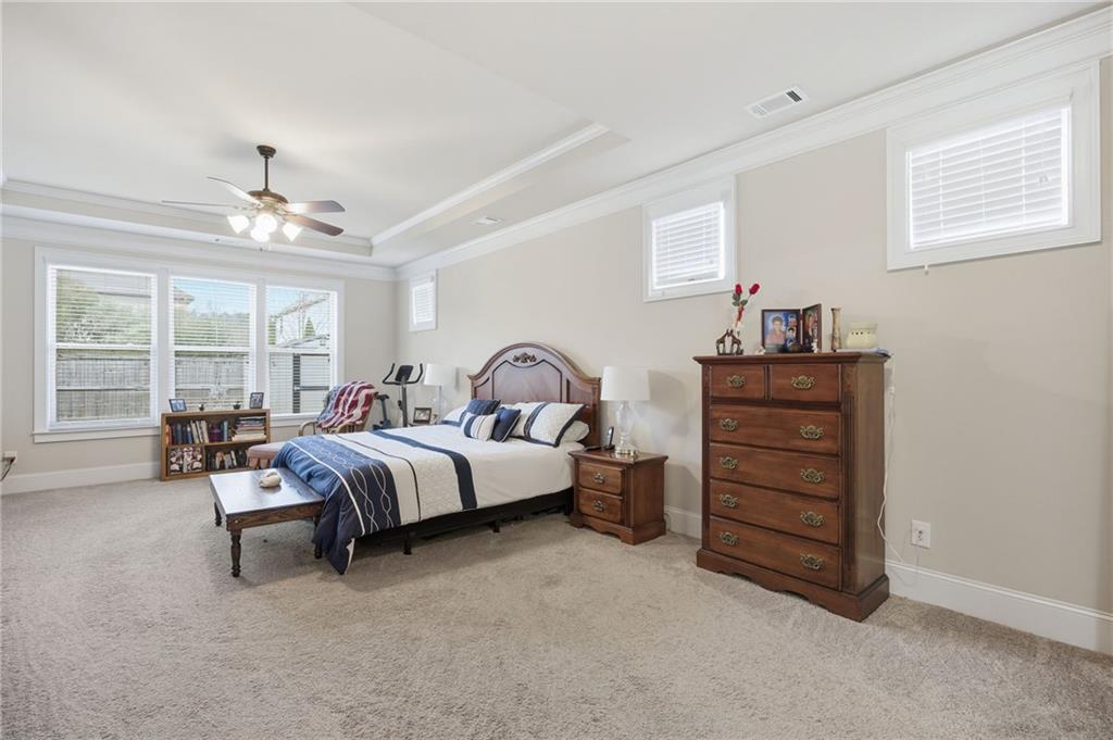 79 Gray Trail Acworth, GA 30101 - Photo 24 of 40 a spacious bedroom with a bed and a chandelier