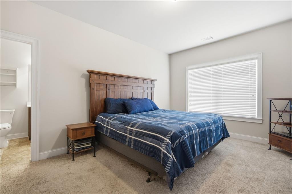 79 Gray Trail Acworth, GA 30101 - Photo 29 of 40 a bed sitting in a bedroom next to a window and a chair