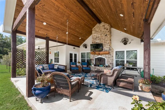 a living room with furniture a fireplace and a floor to ceiling window