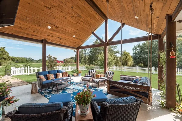 a living room with patio furniture and a garden