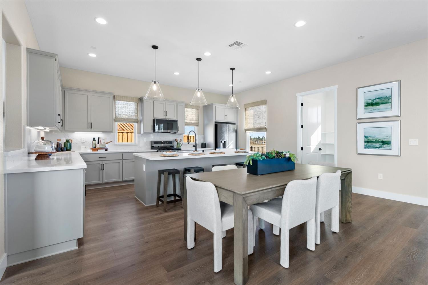 1815 Foster Lane Davis, CA 95616 - Photo 16 of 44 a kitchen with stainless steel appliances kitchen island wooden floors and white cabinets
