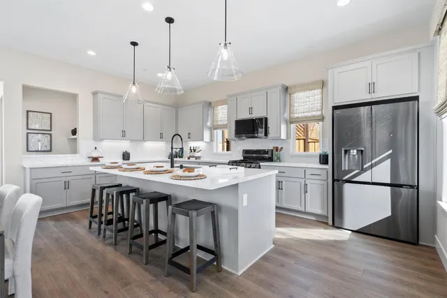 a kitchen with kitchen island granite countertop a sink a center island and stainless steel appliances