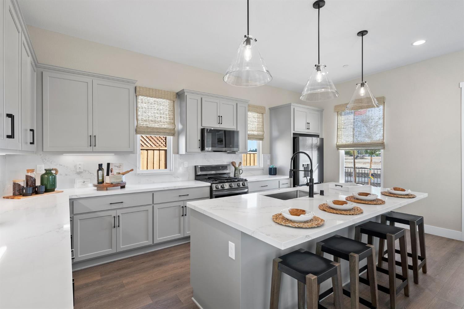 1815 Foster Lane Davis, CA 95616 - Photo 19 of 44 a kitchen that has a lot of cabinets a sink a stove and chairs with wooden floor