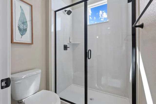 a bathroom with a toilet and a shower