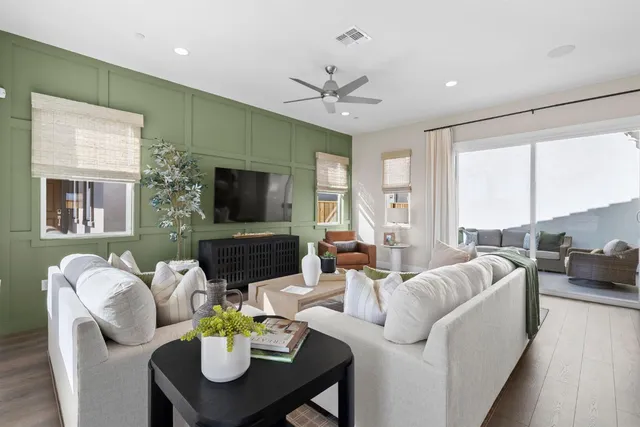 a living room with furniture a flat screen tv and a large window