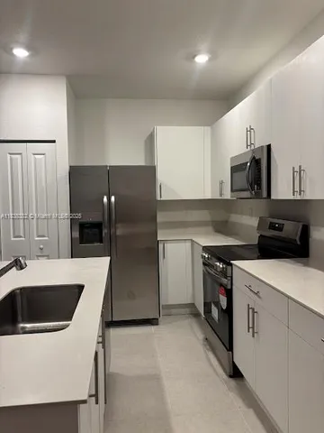 a kitchen that has a sink and a stove in it