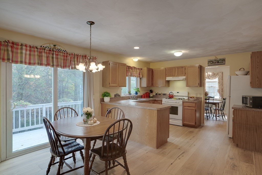 4 Carbone Circle Maynard, MA 01754 - Photo 9 of 38 a view of a dining room and livingroom with furniture wooden floor a chandelier