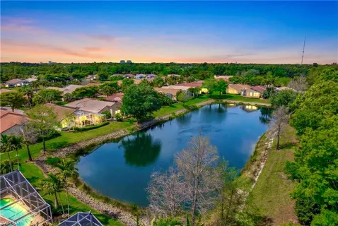 an aerial view of city lake and trees all around