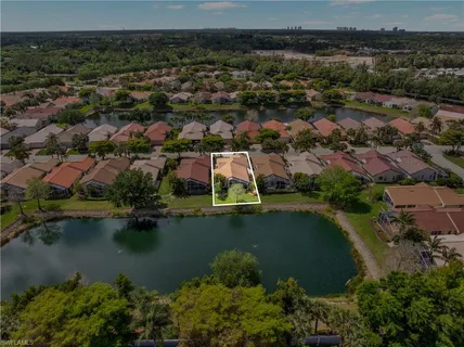 an aerial view of residential houses with outdoor space and lake view
