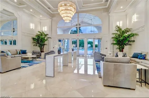a living room with furniture a chandelier and a clock
