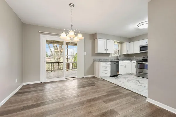 a open kitchen that has a lot of cabinets and a wooden floor