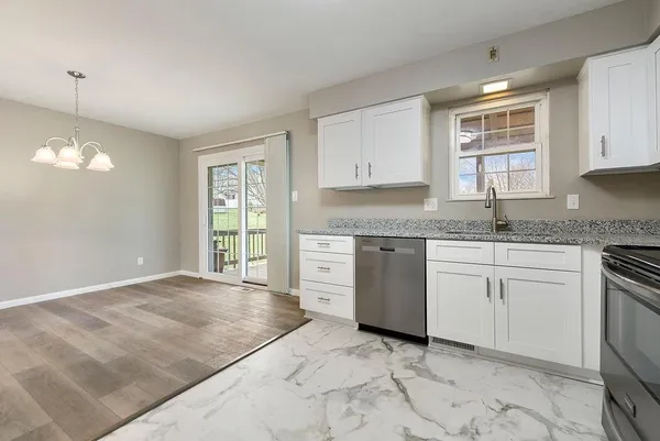 a kitchen with granite countertop a stove a sink and a window