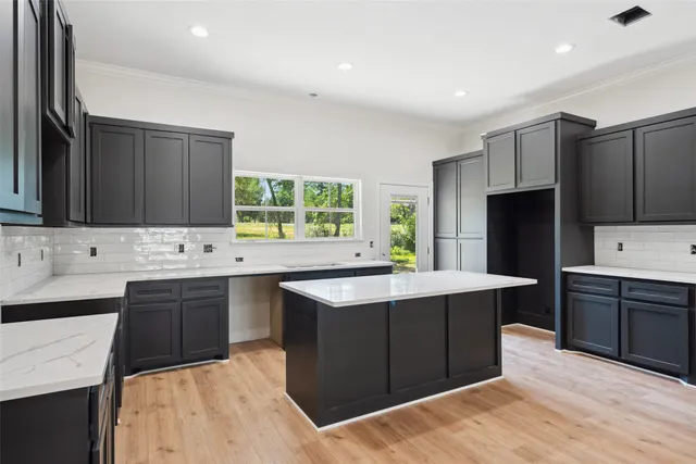 a kitchen with stainless steel appliances kitchen island granite countertop a sink stove and refrigerator