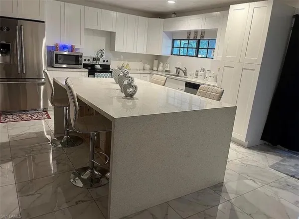 a kitchen with a sink a stove and chairs