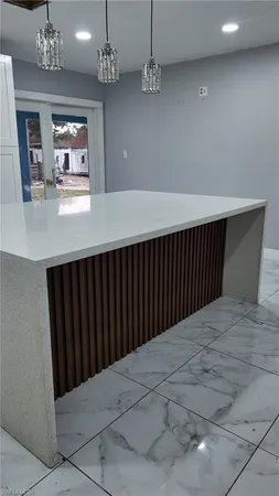 a view of a hallway with a chandelier and wooden floor